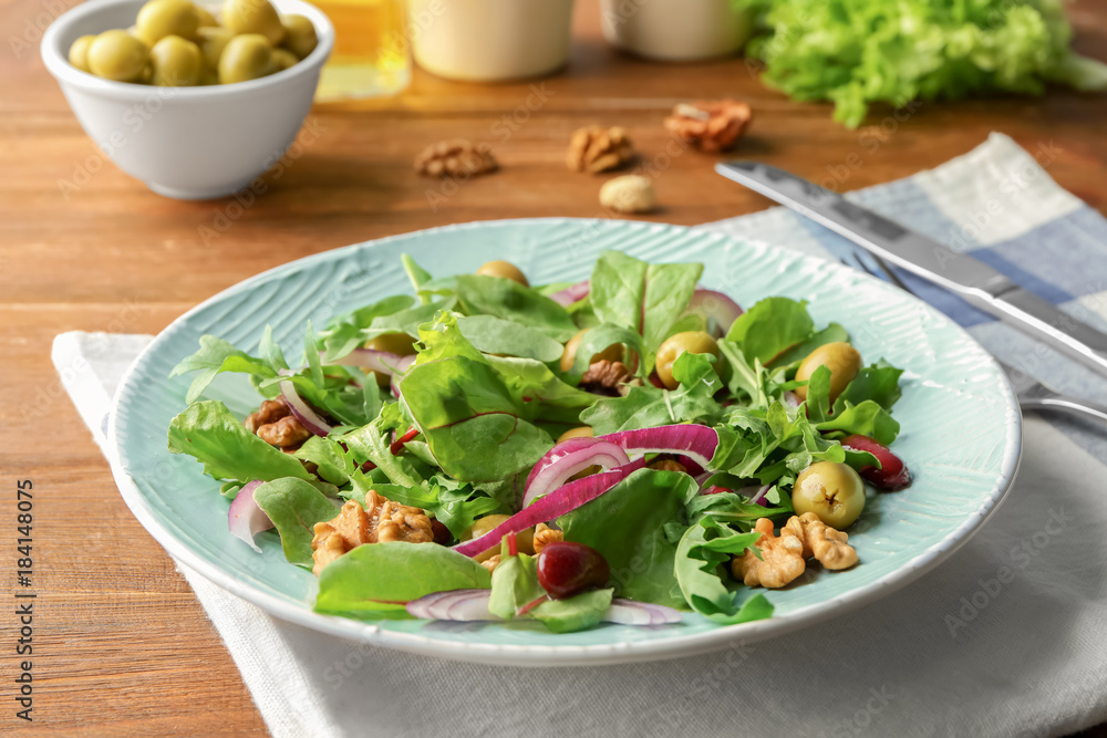 Plate with delicious vegetable salad on table