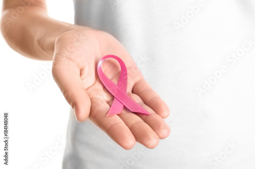 Woman holding pink ribbon on white background. Breast cancer awareness concept