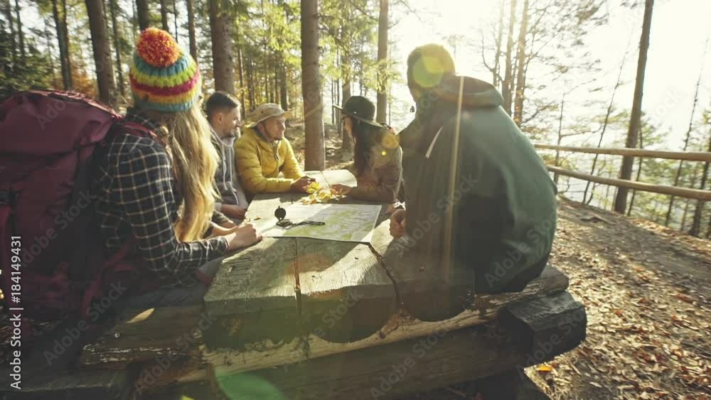 Hikers planning route at table in woods Hikers planning route at table in woods