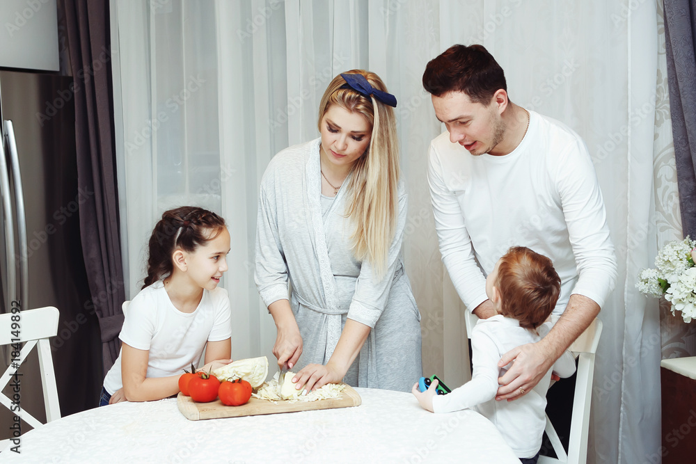 Happy family preparing vegetables together at home in the kitchen