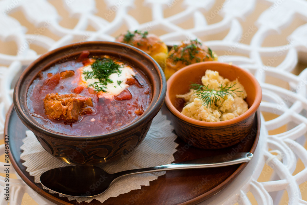Ukrainian national cuisine, red borsch with meat and sour cream on a tray with lard and garlic dumplings Ukrainian national cuisine, red borsch with meat and sour cream on a tray with lard and garlic dumplings
