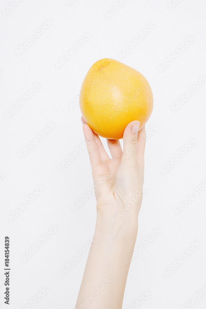 Woman holding a grapefruit in her hands. Young woman with citrus. Woman holding a grapefruit in her hands. Young woman with citrus.
