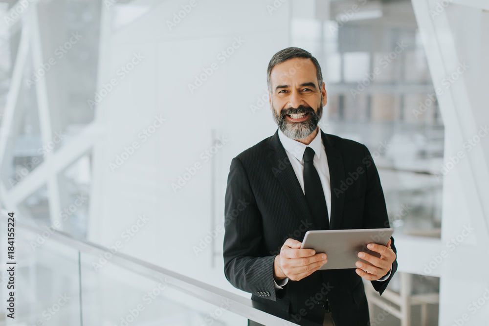 Middle age businessman with tablet in the office Middle age businessman with tablet in the office