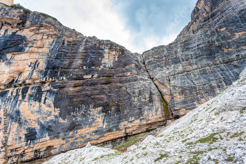 Waterfall on vertical and majestic western side of Tofana di Rozes Peak, Travenanzes Valley, Dolomites, Italy photo