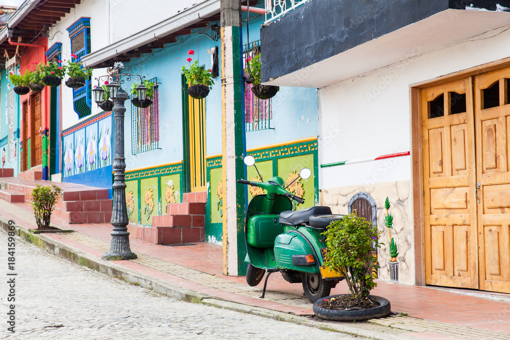 Obraz premium Green motorcycle at the colorful town of Guatape, Antioquia – Colombia.