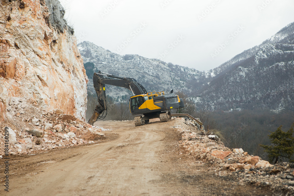 Construction of a mountain road. Demolition of stone. Two breakers are working Construction of a mountain road. Demolition of stone. Two breakers are working