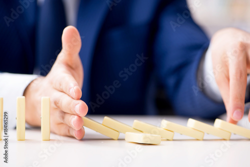 Young businessman playing with domino in office