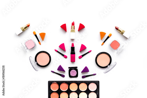 Makeup set pattern. Eyeshadows, rouge, nailpolish, lipstick, applicators on white background top view