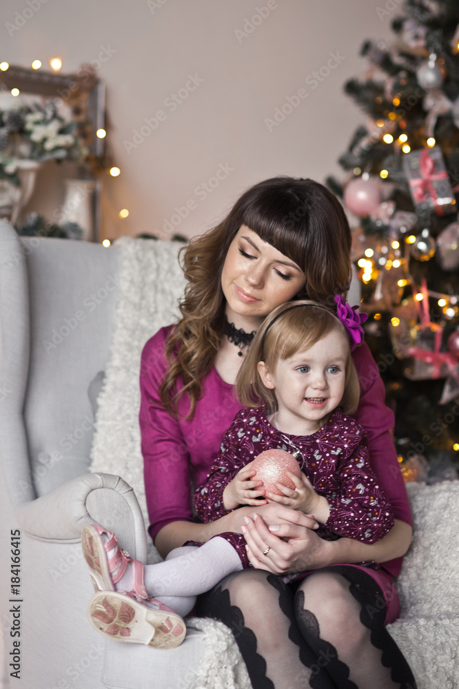 The gentle embrace of mother and daughter on the Christmas decoration The gentle embrace of mother and daughter on the Christmas decoration