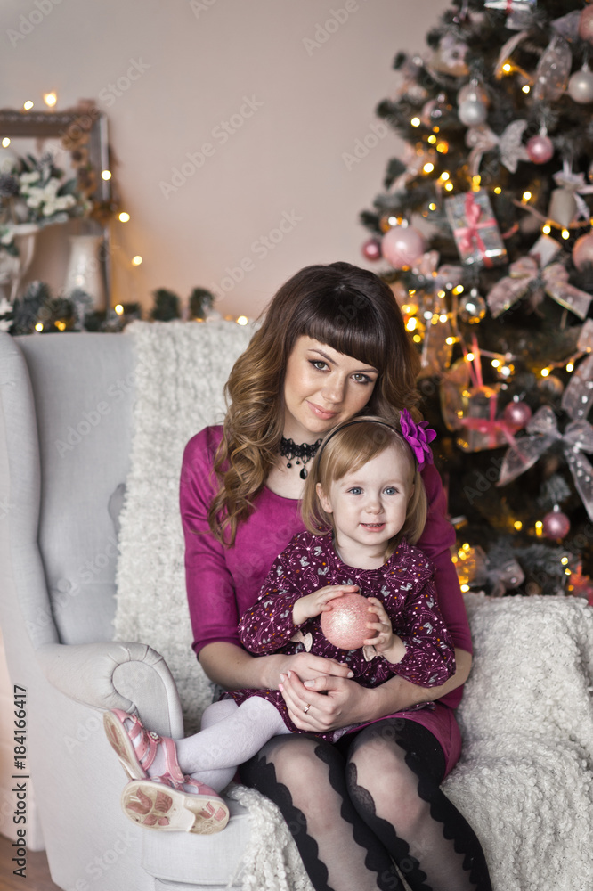 The gentle embrace of mother and daughter on the Christmas decoration The gentle embrace of mother and daughter on the Christmas decoration