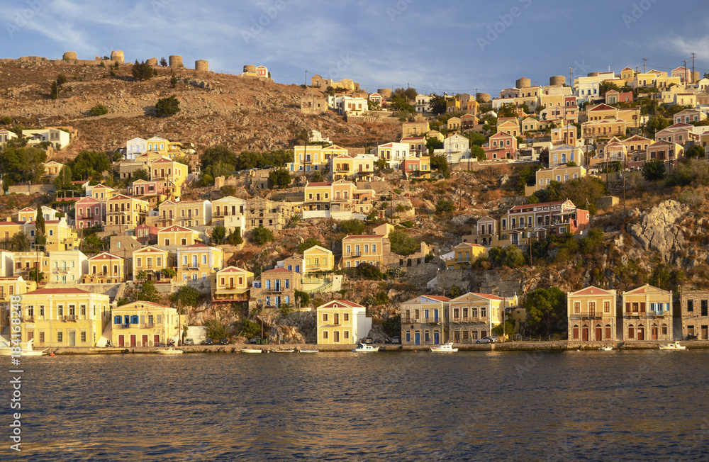 The island and the city of Symi in the rays of the evening sun in Greece.