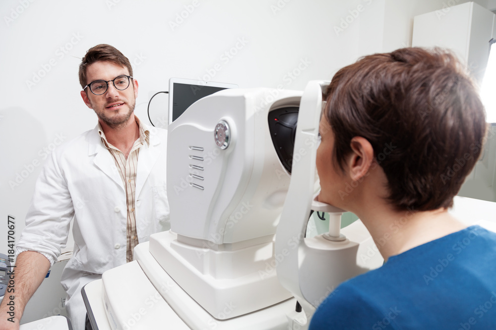 Obraz premium eye Doctor is measuring a patient's visual field with the OCT test /Ophthalmologist in eyes clinic is doing diagnostic vision exam/ concept health and eyes care