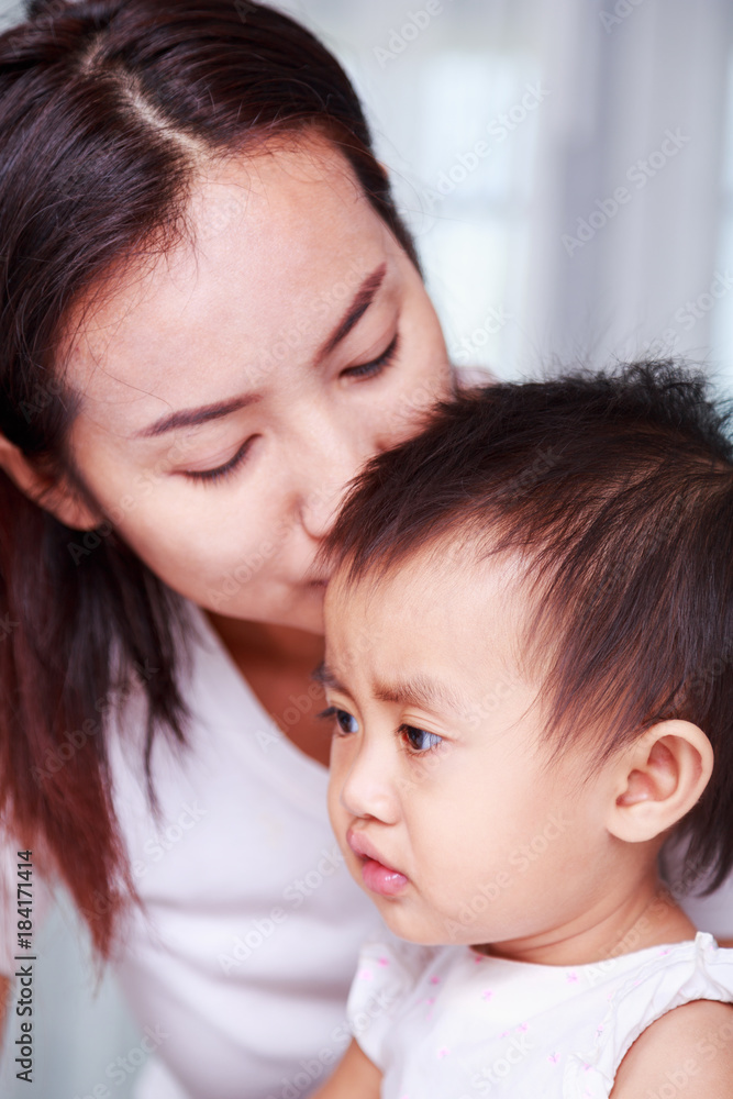 mother kissing head of baby mother kissing head of baby