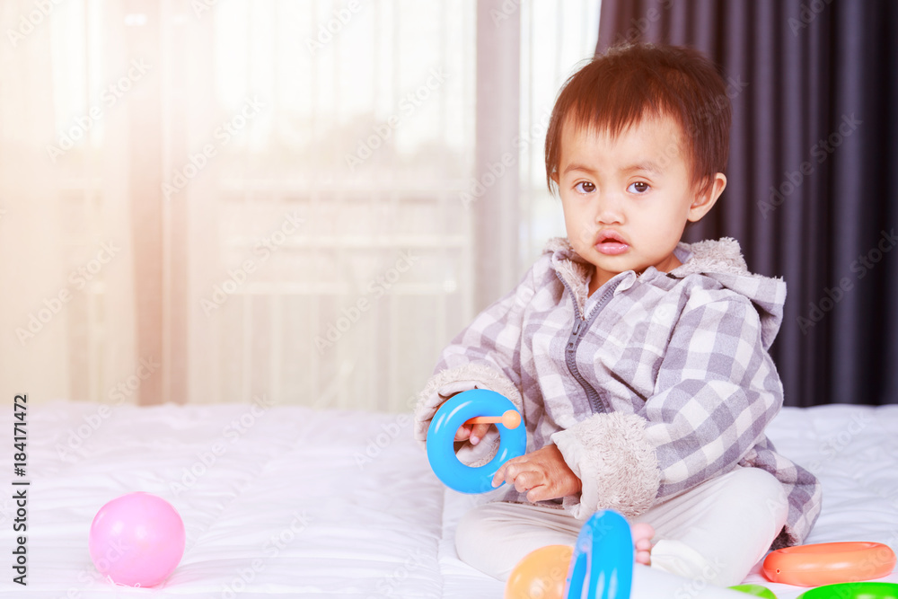 baby playing with toy on bed baby playing with toy on bed