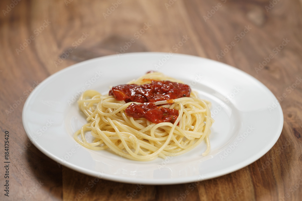 spaghetti bolognese on white plate on wood table