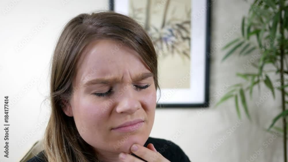 Portrait of beautiful brunnette woman in modern room with sore chin or jaw Portrait of beautiful brunnette woman in modern room with sore chin or jaw