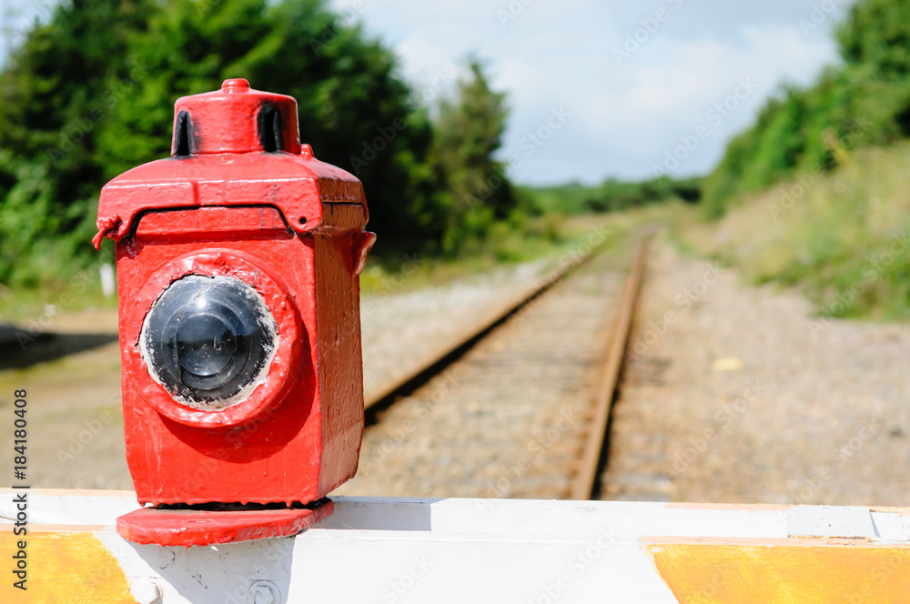 Manually operated level crossing barrier with paraffin warning lamp light across a train railway track Manually operated level crossing barrier with paraffin warning lamp light across a train railway track