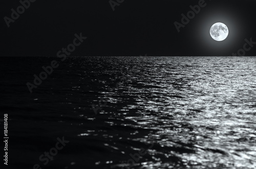 moonlight on the waves at night in the sea on long exposures. black and white photo.