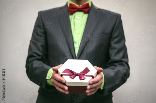 Man in suit holds in hands present box trophy isolated on white. Award ceremony.