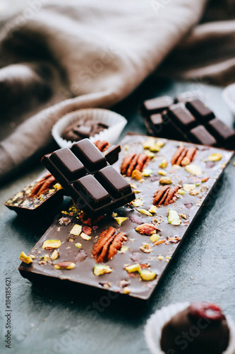 Raw homemade chocolate with nuts, cranberris on black background photo