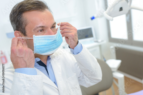 male dentist putting on mask