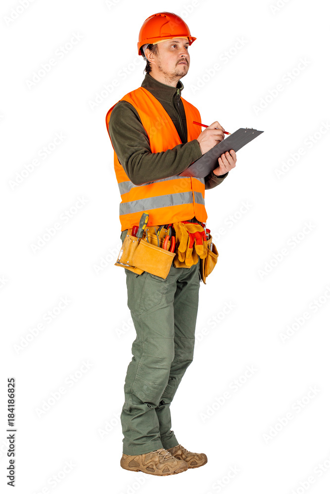 male builder or manual worker in helmet writing on clipboard over white wall background. male builder or manual worker in helmet writing on clipboard over white wall background.