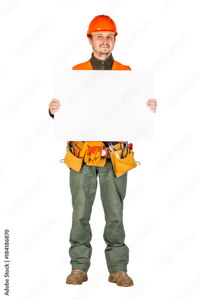 male builder or manual worker in helmet with white blank banner over white wall background. male builder or manual worker in helmet with white blank banner over white wall background.