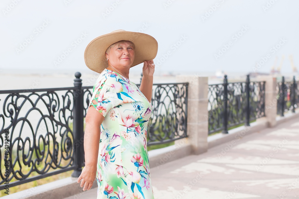 An elderly woman posing, sea on a background.