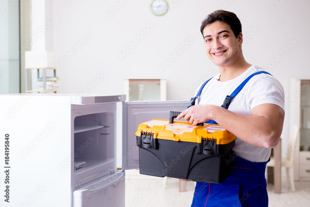 Repairman contractor repairing fridge in DIY concept Repairman contractor repairing fridge in DIY concept