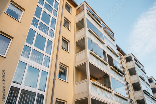 yellow apartment building in low angle view with big balcony