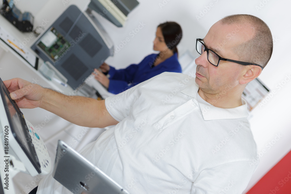 Obraz premium technician using tablet pc while analysing server