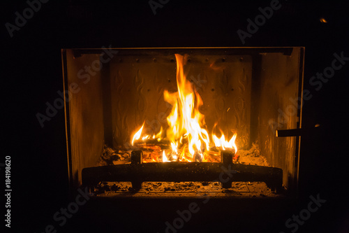 Orange flames of fire in fireplace, background, orange