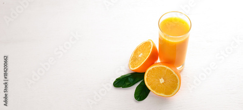 Orange fresh juice and oranges on a wooden surface. Top view. Free space for text.
