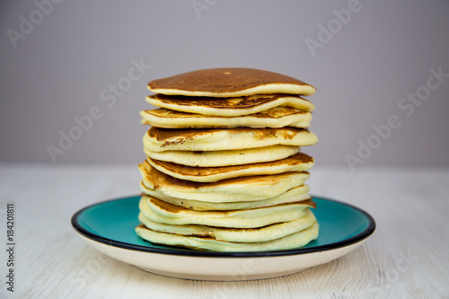 breakfast stack of puffy pancakes on a turquoise plate