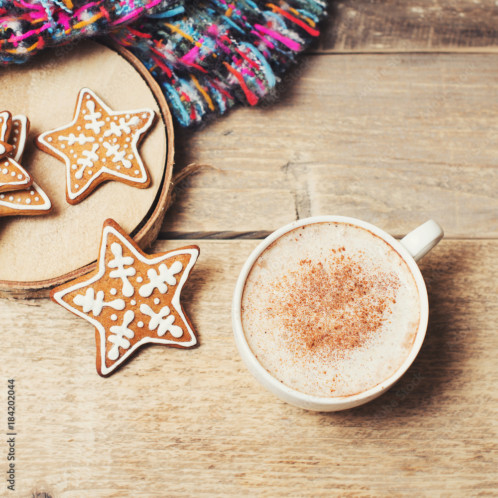 Gingerbread with cup of coffee and cozy scarf on wooden background Gingerbread with cup of coffee and cozy scarf on wooden background