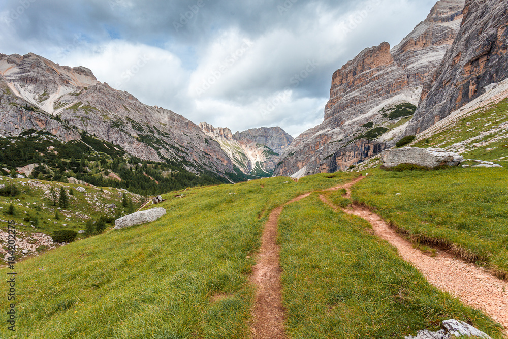 Path in wild Travenanzes valley with Vallon Bianco and Nemesis Mounts background, Dolomites, Italy Path in wild Travenanzes valley with Vallon Bianco and Nemesis Mounts background, Dolomites, Italy
