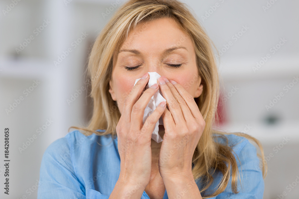woman with cold blowing her nose woman with cold blowing her nose