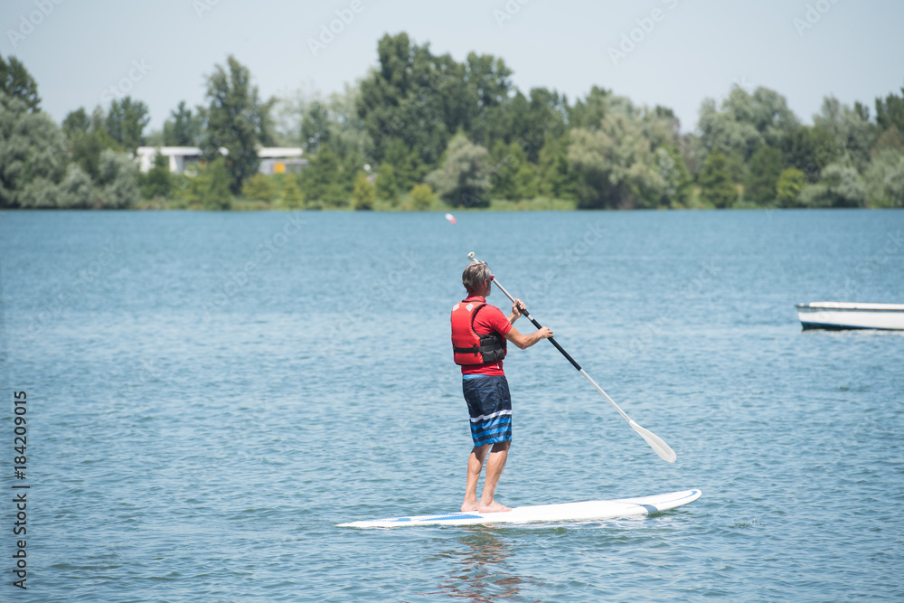 man enjoying a ride on the lake with paddleboard