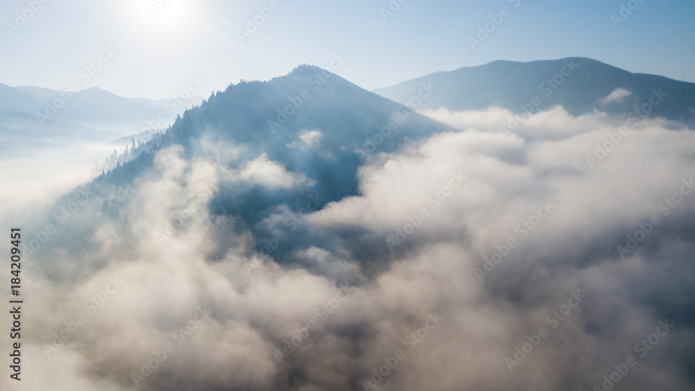 Obraz premium Aerial view of the mountains with a morning fog