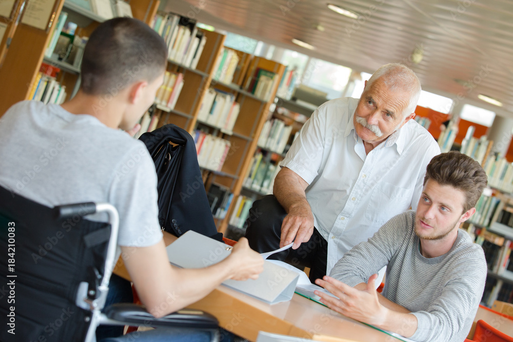 Fototapeta premium handicapped teenager doing his homework with teacher