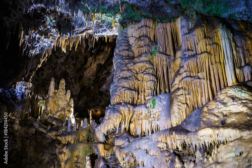 Postojna cave, Slovenia. Formations inside cave with stalactites and stalagmites. Low light image. photo