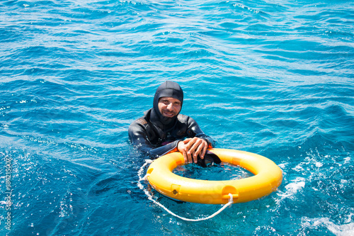 snorkeling and scuba diving in Red sea. Handsome sexy diver on the background of azure sea. Water rescue operation © Viktoria