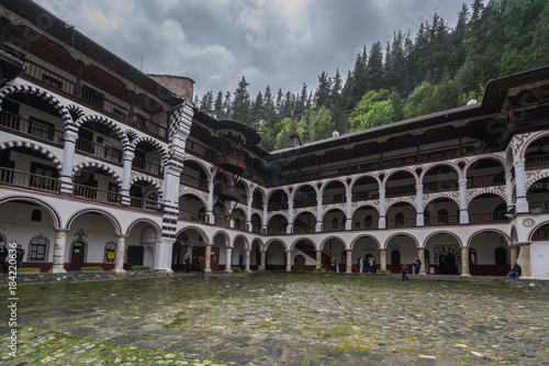 Buildings of Rila Monastery have a distinct architectural style with many archs and black and white colors. Rila, Bulgaria, June 2017 photo