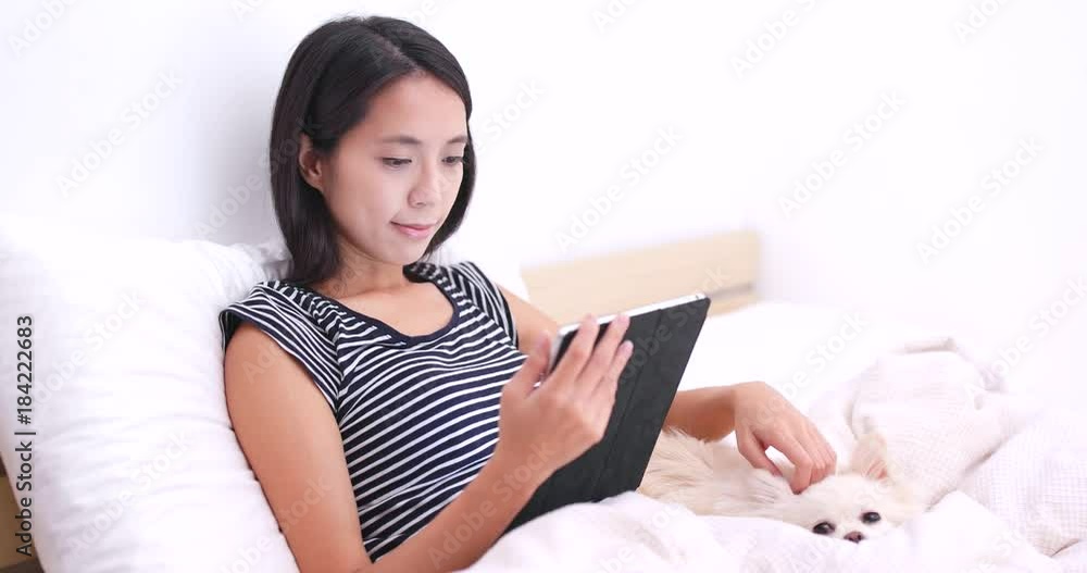 Woman watching on tablet computer with her dog Woman watching on tablet computer with her dog