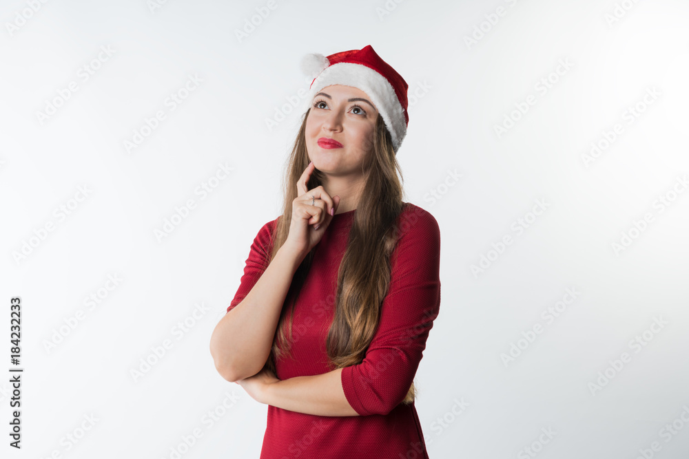 portrait of young christmas woman wearing red santa claus hat dreaming having idea, isolated on white background, copy space portrait of young christmas woman wearing red santa claus hat dreaming having idea, isolated on white background, copy space