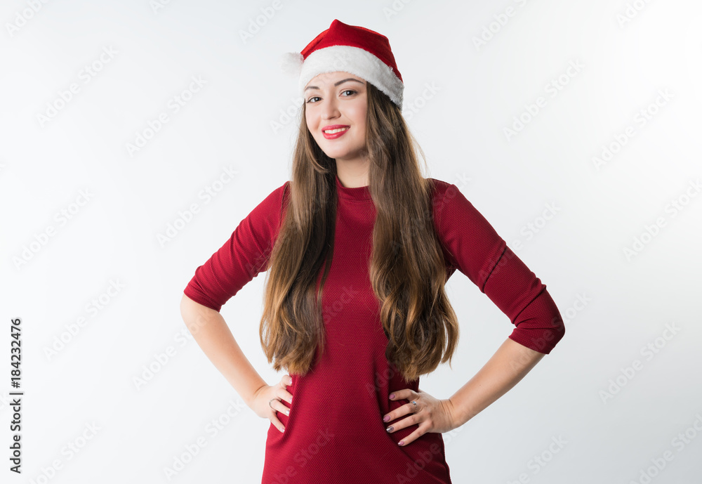 portrait of young cheerful christmas woman wearing red santa claus hat on white background, copy space. She looks happy portrait of young cheerful christmas woman wearing red santa claus hat on white background, copy space. She looks happy