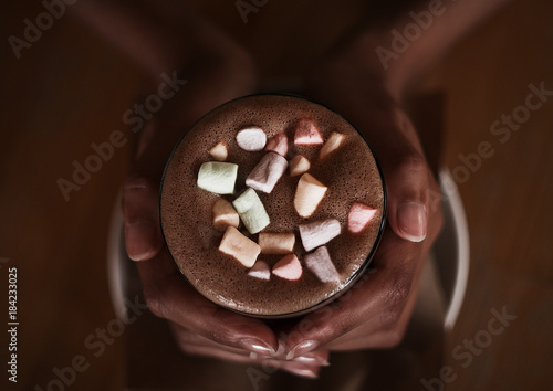 hands of an African girl holding cocoa with a marshmallow