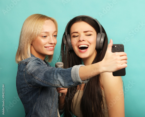 lifestyle, emotion  and people concept: Happy girls  with microp photo