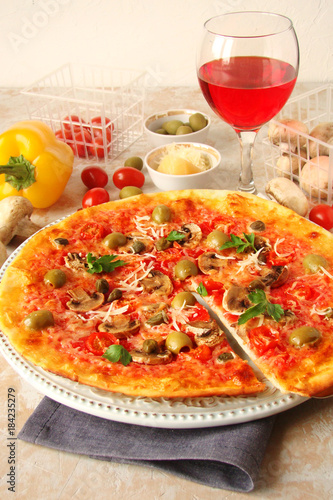 Pizza with tomatoes, mushrooms, black olives, Parmesan cheese, capers