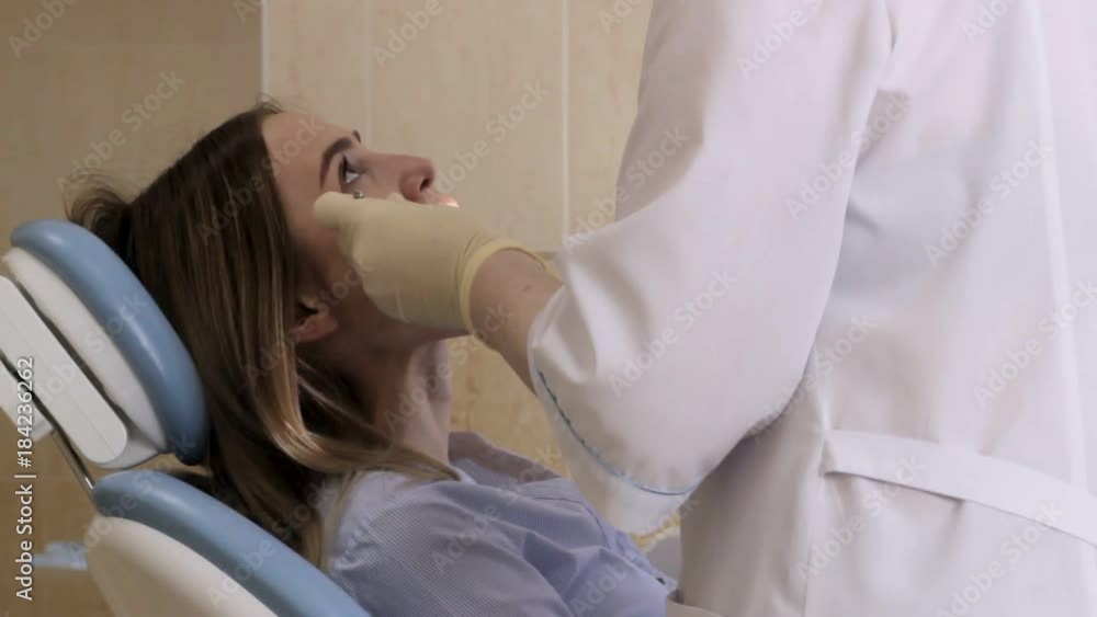 Doctor dentist at work, checking teeth of young girl Doctor dentist at work, checking teeth of young girl
